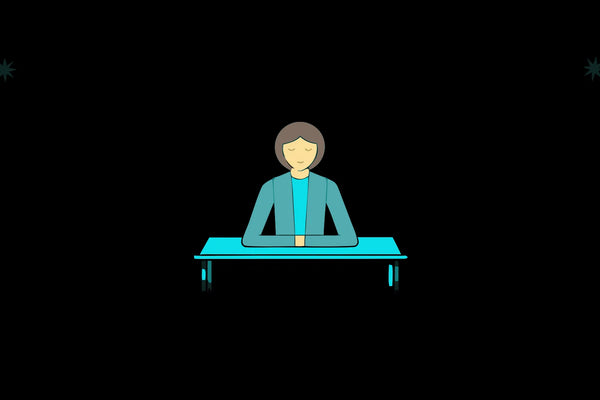 A person at a desk with eyes closed, taking a moment to regulate their nervous system.