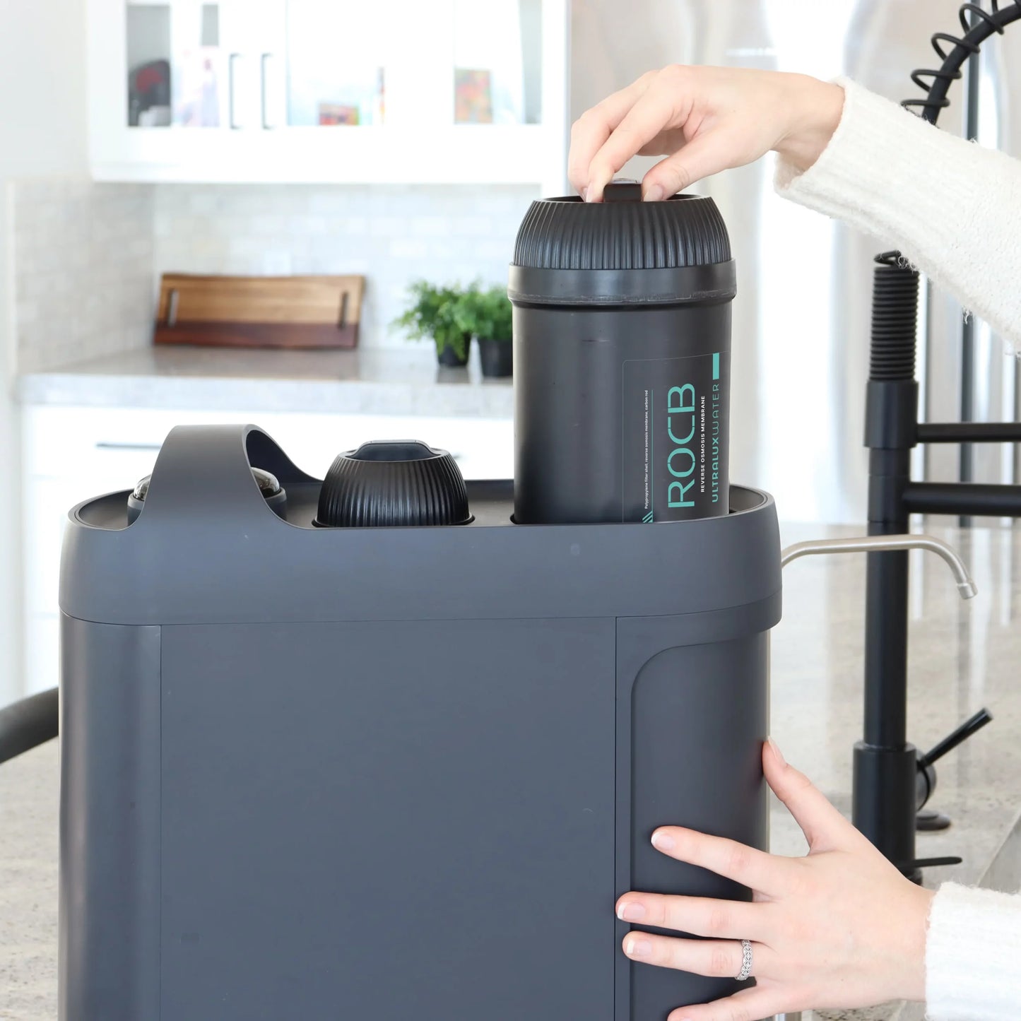 A woman easily changes a reverse osmosis water filter in the UltraLux Water Machine.