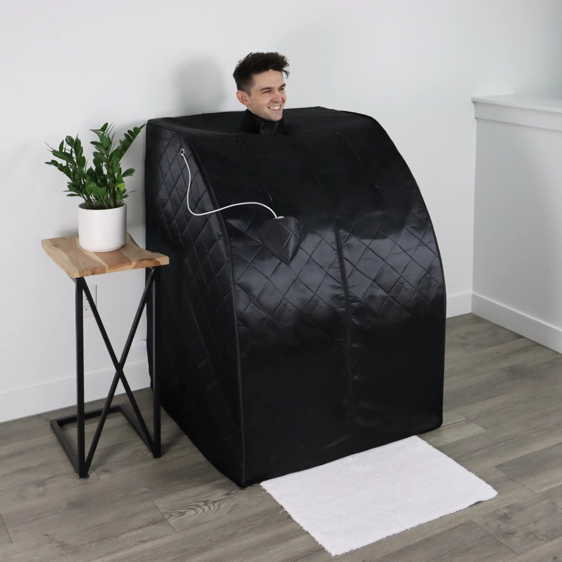 A man relaxing in a portable infrared sauna.